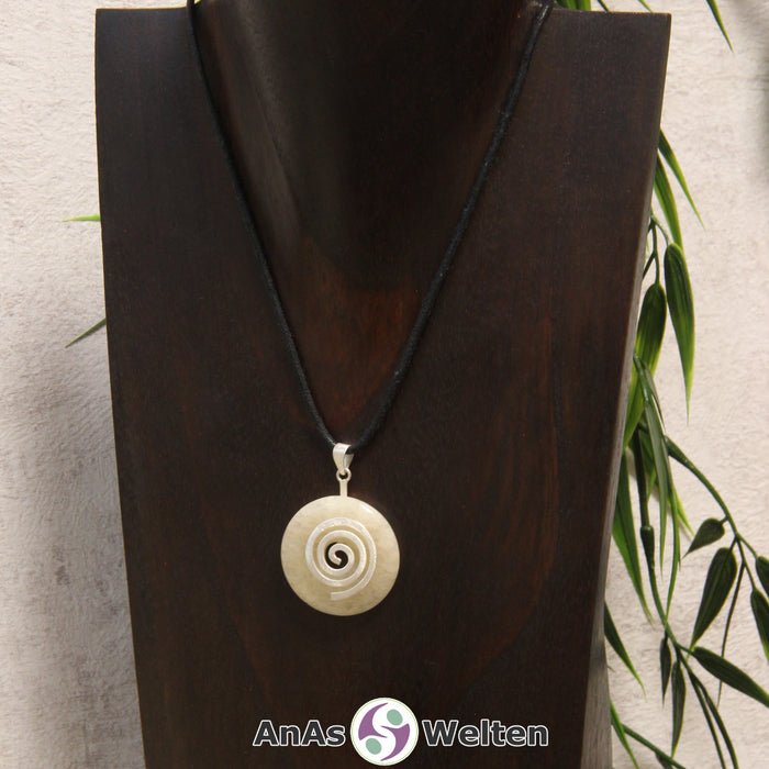 Ein Orangencalcit Donut an einem Donut-Halter Spirale, der mit einem gewachsten Baumwollband um eine dunkle Büste hängt.