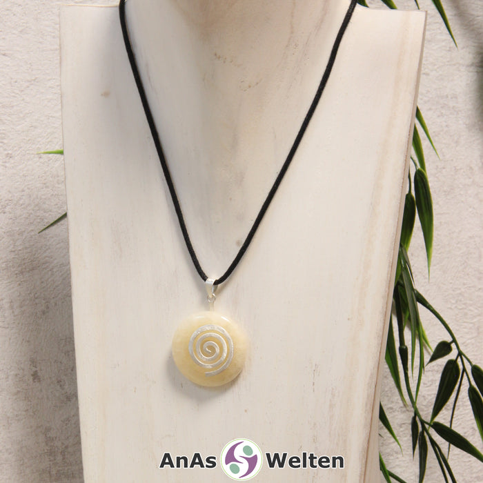 Ein Orangencalcit Donut an einem Donut-Halter Spirale, der mit einem gewachsten Baumwollband um eine helle Büste hängt.