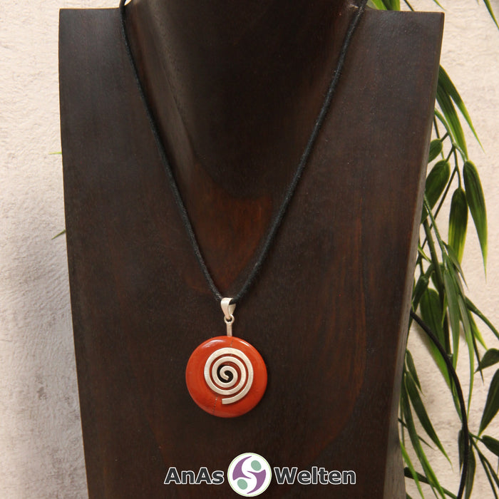 Ein Roter Jaspis Donut an einem Donut-Halter Spirale, der mit einem gewachsten Baumwollband um eine dunkle Büste hängt.