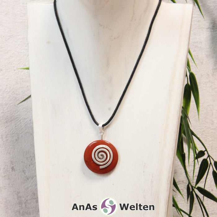 Ein Roter Jaspis Donut an einem Donut-Halter Spirale, der mit einem gewachsten Baumwollband um eine helle Büste hängt.