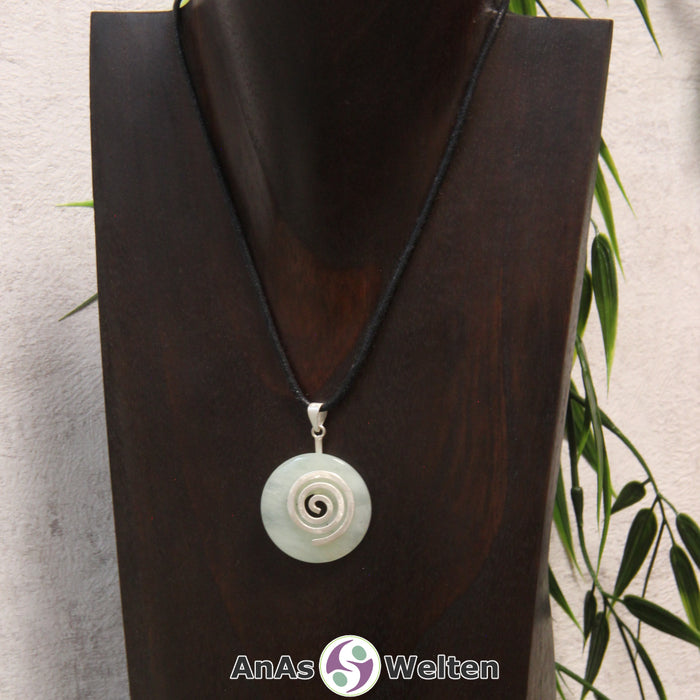 Ein Serpentin Donut an einem Donut-Halter Spirale, der mit einem gewachsten Baumwollband um eine dunkle Büste hängt.