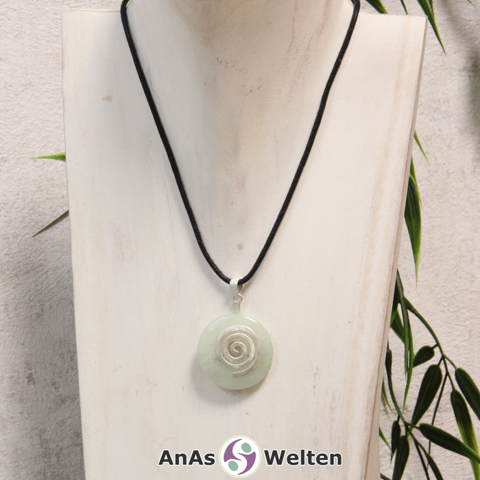 Ein Serpentin Donut an einem Donut-Halter Spirale, der mit einem gewachsten Baumwollband um eine helle Büste hängt.