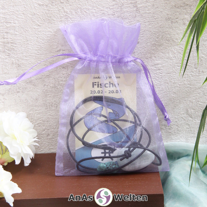 Ein beispielhaftes Sternzeichen Steine Set Fische mit Karte, Trommelstein und Edelsteinkette in einem lila Organzabeutel.