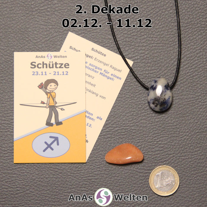 Die Sternzeichenkarte und je ein beispielhafter gebohrter Sodalith Trommelstein am Band und ein Dolomit Trommelstein der 2. Dekade liegen nebeneinander.