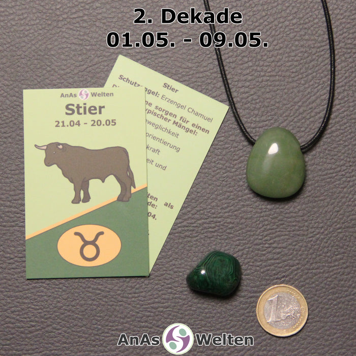 Die Sternzeichenkarte und je ein beispielhafter gebohrter Aventurin Trommelstein am Band und ein Malachit Trommelstein der 2. Dekade liegen nebeneinander.