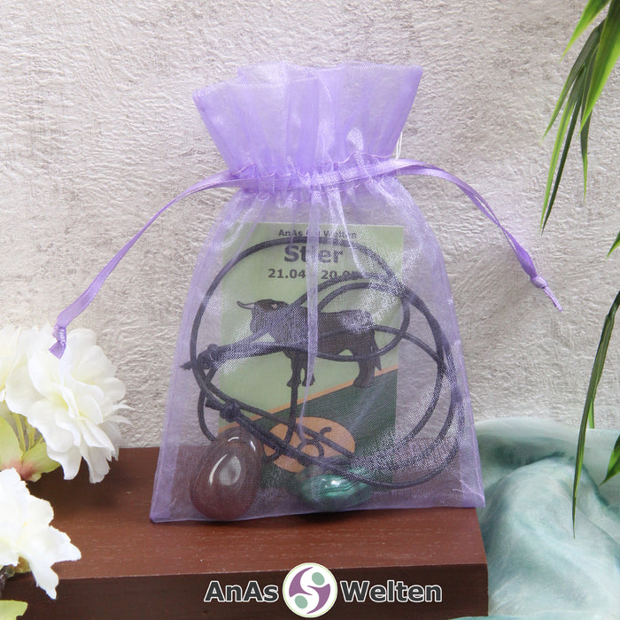 Ein beispielhaftes Sternzeichen Steine Set Stier mit Karte, Trommelstein und Edelsteinkette in einem lila Organzabeutel.