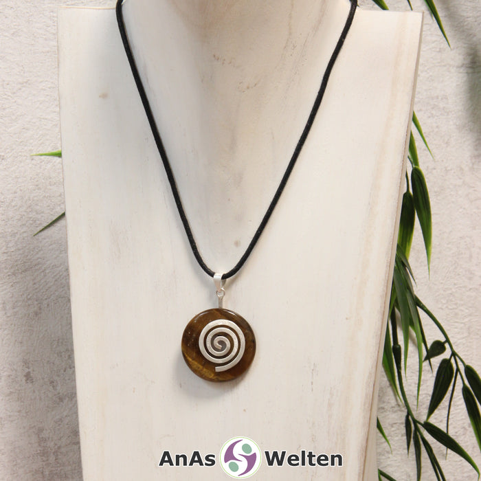 Ein Tigerauge Donut an einem Donut-Halter Spirale, der mit einem gewachsten Baumwollband um eine helle Büste hängt.