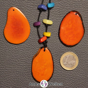 Drei orangene Tagua-Nuss-Scheiben. Eine davon ist mit 6 Tagua-Nuss-Splittern in den Chakra-Farben als Kette gebunden.
