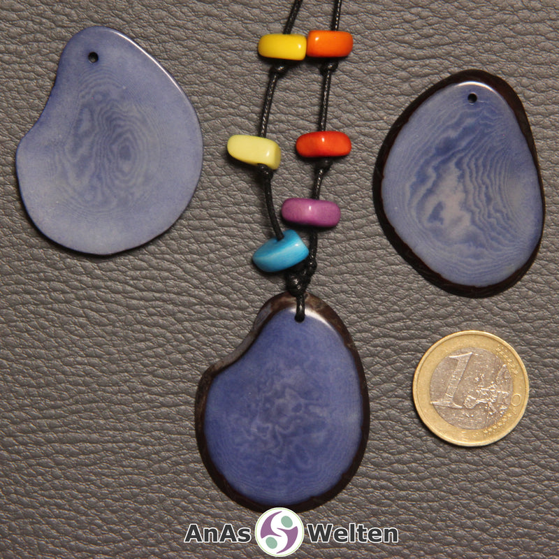Drei blaue Tagua-Nuss-Scheiben. Eine davon ist mit 6 Tagua-Nuss-Splittern in den Chakra-Farben als Kette gebunden.