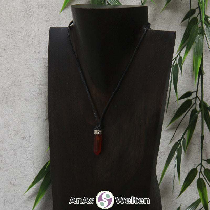 Eine dunkelrote Karneol Stift-Anhänger klein Kette mit einem Metallelement über dem Edelstein an einer dunklen Büste.