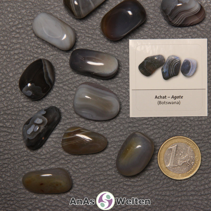 Mehrere Beispiele für den Achat Trommelstein. Daneben liegt der Sticker.