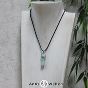 Ein Amazonit Stift-Anhänger groß mit Metallöse, der mit einem schwarzen Baumwollband um eine dunkle Büste gehängt wurde