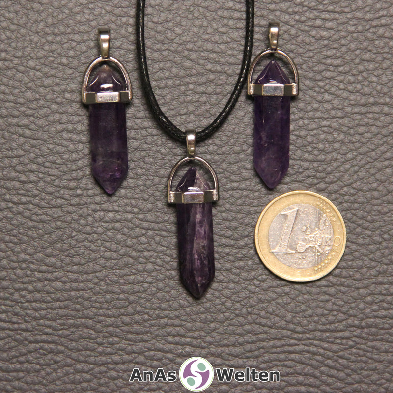 Drei Doppelspitze Stift-Anhänger aus Amethyst nebeneinander. Einer befindet sich an einem schwarzen Baumwollband.