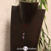 Eine lila-weiße Amethyst Stift-Anhänger klein Kette mit einem Metallelement über dem Edelstein an einer hellen Büste.