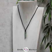 Eine grüne Aventurin Stift-Anhänger klein Kette mit einem Metallelement über dem Edelstein an einer dunklen Büste.