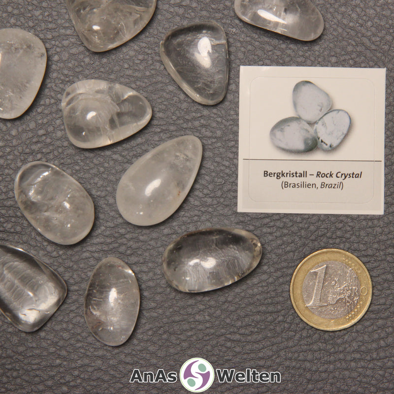 Mehrere Beispiele für den Bergkristall Trommelstein. Daneben liegt der Sticker.