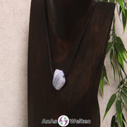 Ein gebohrter blauer Chalcedon Trommelstein an einem Baumwollband. In dem Edelstein kann man gut die verschiedenen Schichten aus unterschiedlichen Blautönen sehen, wodurch er gestreift aussieht.