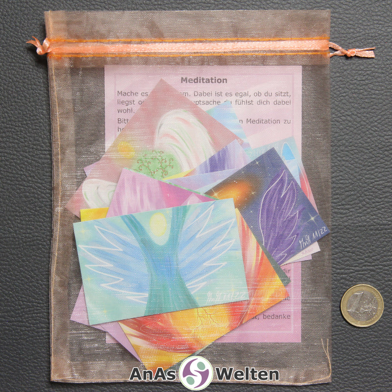 Die 15 Engel Karten und die Meditationskarte in einem orangenen Organzabeutel.