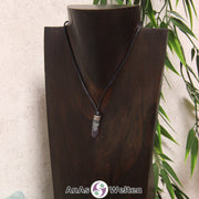 Eine grün-lila Fluorit Stift-Anhänger klein Kette mit einem Metallelement über dem Edelstein an einer dunklen Büste.