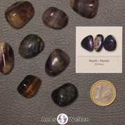 Mehrere Beispiele für den Fluorit Trommelstein. Daneben liegt der Sticker.