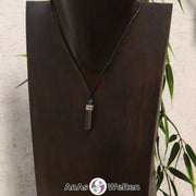 Eine dunkelgraue Hämatin Stift-Anhänger klein Kette mit einem Metallelement über dem Edelstein an einer hellen Büste.