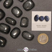 Mehrere Beispiele für den Hämatit Trommelstein. Daneben liegt der Sticker.