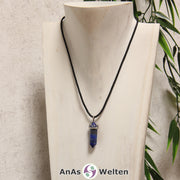 Ein Lapislazuli Stift-Anhänger groß mit Metallöse, der mit einem schwarzen Baumwollband um eine helle Büste gehängt wurde