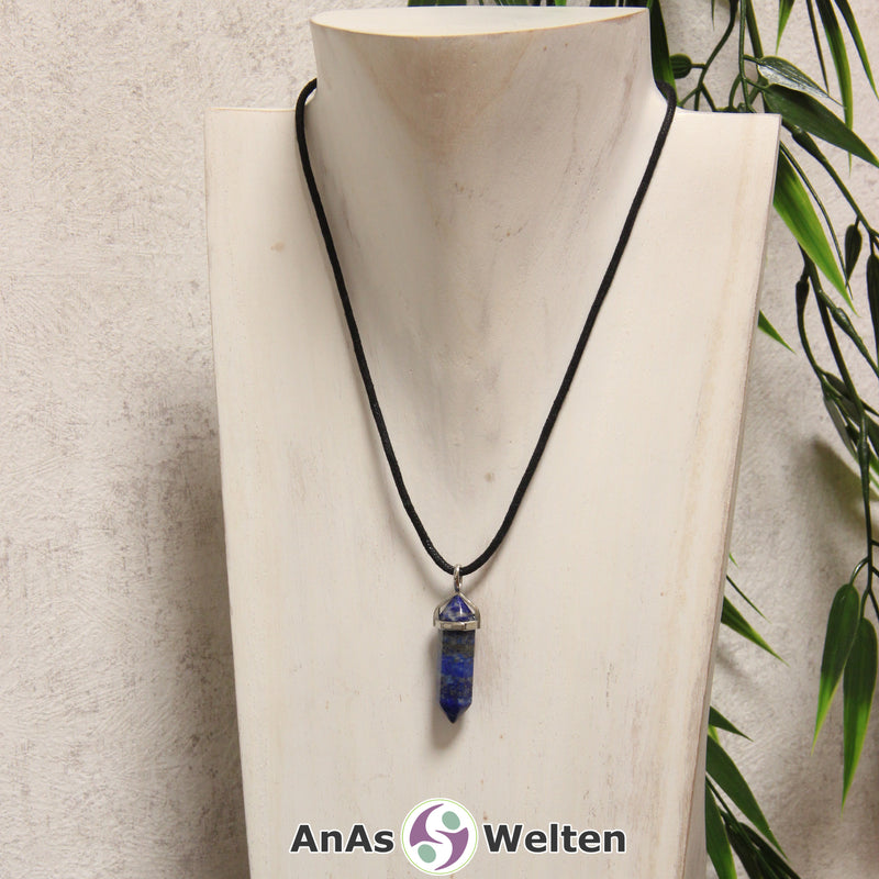 Ein Lapislazuli Stift-Anhänger groß mit Metallöse, der mit einem schwarzen Baumwollband um eine helle Büste gehängt wurde