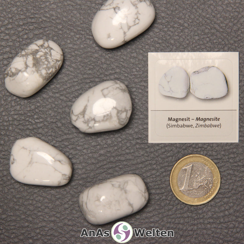 Mehrere Beispiele für den Magnesit Trommelstein. Daneben liegt der Sticker.