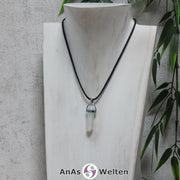 Ein Opalglas Stift-Anhänger groß mit Metallöse, der mit einem schwarzen Baumwollband um eine dunkle Büste gehängt wurde