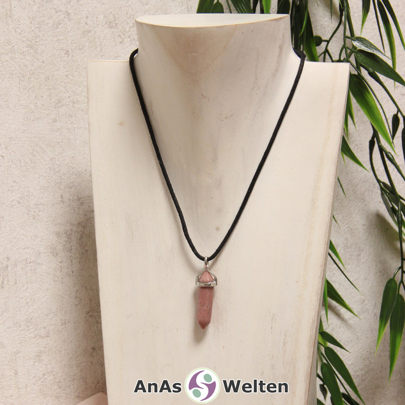 Ein Rhodonit Stift-Anhänger groß mit Metallöse, der mit einem schwarzen Baumwollband um eine helle Büste gehängt wurde