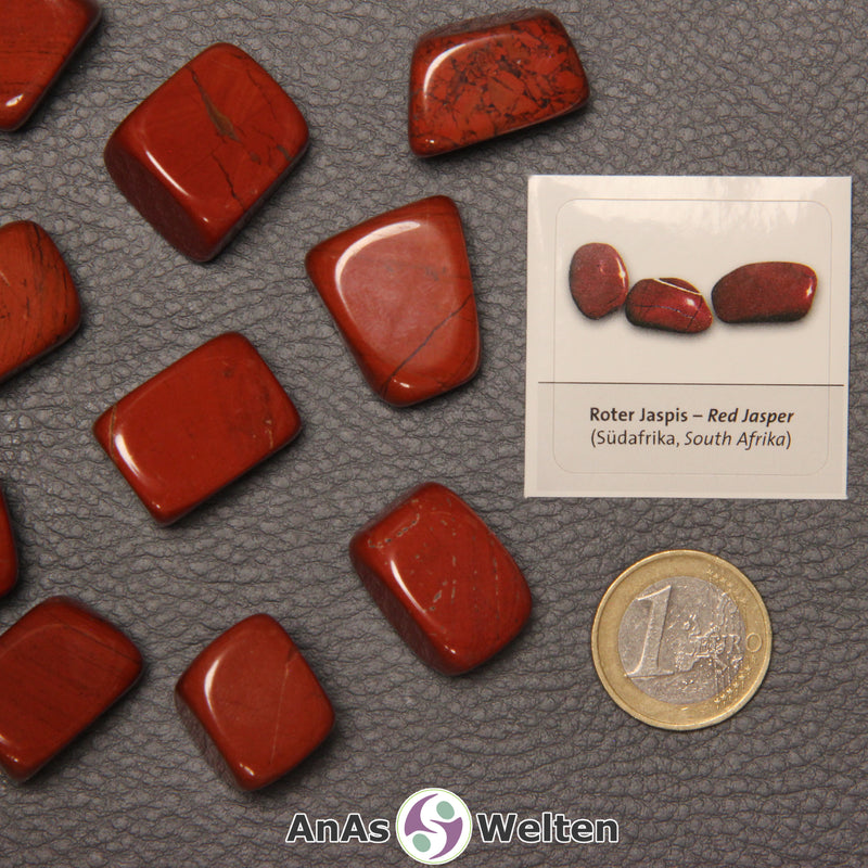 Mehrere Beispiele für den Roter Jaspis Trommelstein. Daneben liegt der Sticker.