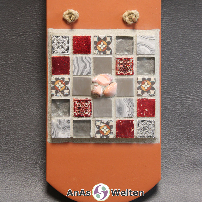 Frontale Ansicht des Sator Quadrat Mosaik aus grauen, roten und weißen Fliesen mit rosa Achaten in der Mitte.