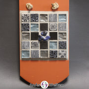 Frontale Ansicht des Sator Quadrat Mosaik aus grauen, graublauen und schwarzen Fliesen mit Sodalithen in der Mitte.