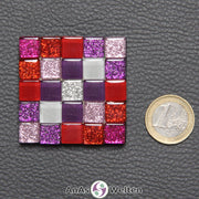 Ein kleines Sator-Quadrat-Mosaik aus pinken, roten, lilafarbenen, weißen und einer silberfarbenen Glasfliese.