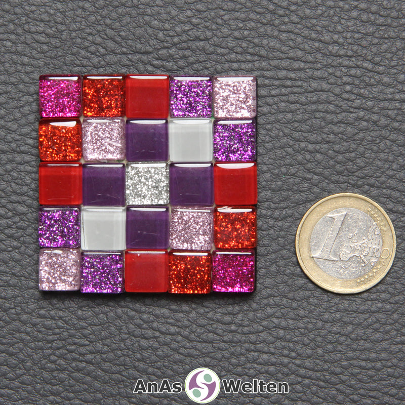 Ein kleines Sator-Quadrat-Mosaik aus pinken, roten, lilafarbenen, weißen und einer silberfarbenen Glasfliese.