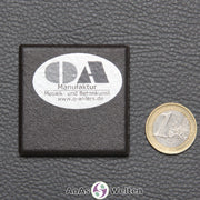 Die Rückseite eines kleinen Sator-Quadrat-Mosaiks, auf der eine silberner Sticker mit der Aufschrift OA Manufaktur ist.