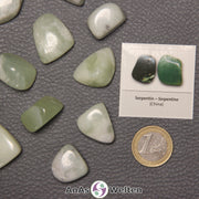 Mehrere Beispiele für den Serpentin Trommelstein. Daneben liegt der Sticker.