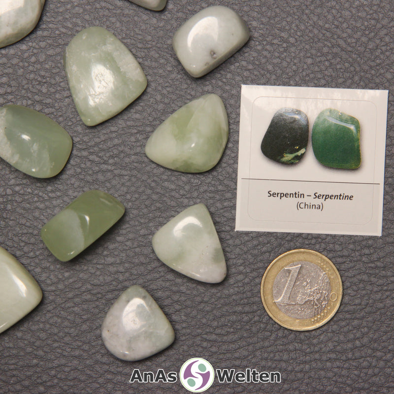 Mehrere Beispiele für den Serpentin Trommelstein. Daneben liegt der Sticker.