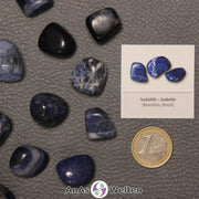 Mehrere Beispiele für den Sodalith Trommelstein. Daneben liegt der Sticker.