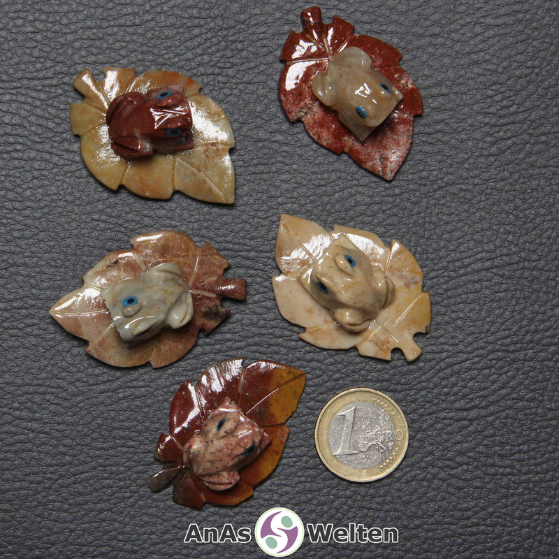 Fünf verschiedene Speckstein Frösche auf Blatt klein, anhand derer man einige verschiedene Färbungen von Speckstein sehen kann.