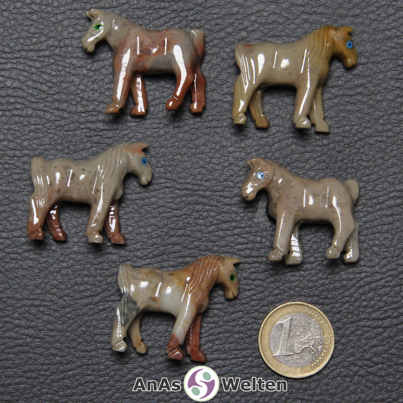 Fünf verschiedene Speckstein Pferde klein, anhand derer man einige verschiedene Färbungen von Speckstein sehen kann.