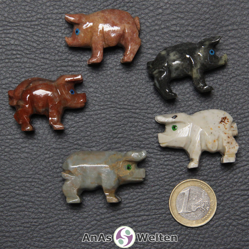 Fünf verschiedene Speckstein Schweine klein, anhand derer man einige verschiedene Färbungen von Speckstein sehen kann.