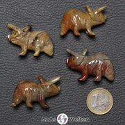 Vier verschiedene Speckstein Triceratops klein, anhand derer man einige verschiedene Färbungen von Speckstein sehen kann.