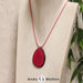 Das Produktbild zeigt die Tagua-Nuss-Schmuck Kette fuchsia. Zu sehen ist eine pinke Tagua-Nuss-Scheibe, die mit einer Edelstahlöse an einem rosa Baumwollband befestigt ist. Die Nuss-Scheibe hat einen dunklen Rand und eine glänzende Oberfläche.