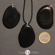 Drei schwarz gefärbte Tagua-Nuss-Scheiben mit Metallöse. Eine ist an einem schwarzen gewachsten Baumwollband.