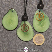 Drei Tagua-Nuss-Scheiben in grün. Zwei davon sind als Kette mit Lavakugel und Jungfrau-Symbol gebunden.