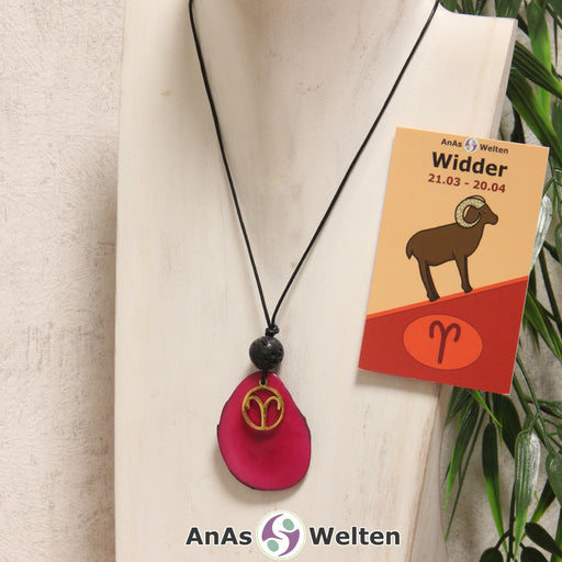 Das Produktbild für die Tagua-Nuss-Schmuck Sternzeichen-Kette Widder zeigt eine fuchsia gefärbte Tagua-Nuss-Scheibe an einem schwarzen Baumwollband, vor der ein goldfarbener Anhänger mit dem Sternzeichensymbol des Widders befestigt ist. Die Nuss-Scheibe hat einen dunklen Rand und eine glänzende Oberfläche. Direkt darüber befindet sich eine Lavakugel. Rechts neben der Kette sieht man außerdem die Sternzeichen Widder Karte von AnAs Welten.