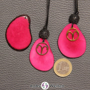 Drei Tagua-Nuss-Scheiben in fuchsia. Zwei davon sind als Kette mit Lavakugel und Widder-Symbol gebunden.