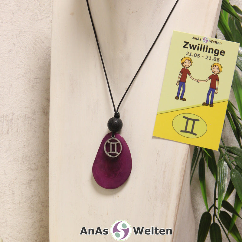 Eine violett gefärbte Tagua-Nuss Sternzeichen Kette mit silberfarbenem Zwillinge-Symbol und Lavakugel an einer hellen Büste.
